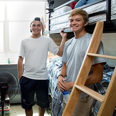 Two U N E students moving into their freshman dorm room